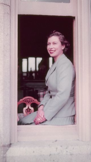 Queen Elizabeth II sitting in the window at Balmoral Castle