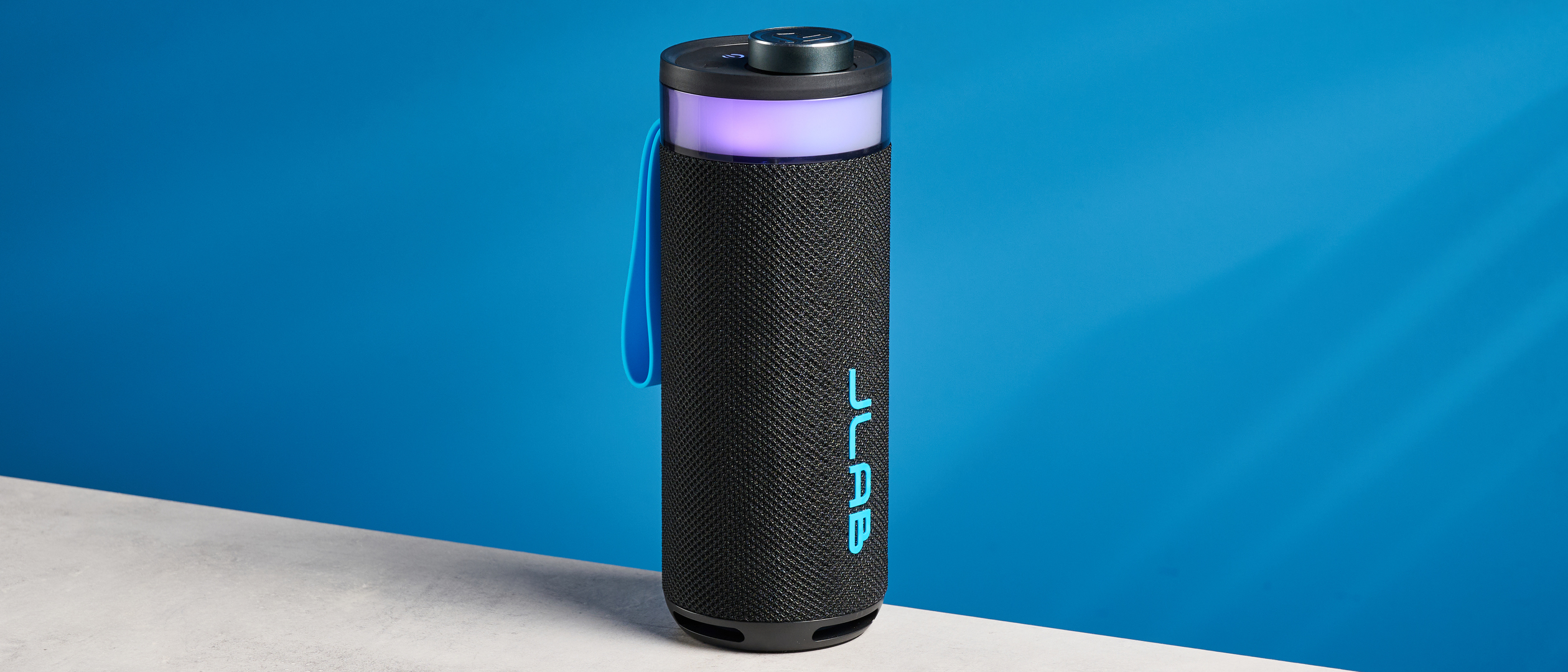the jlab go party speaker in black with an LED RGB panel and jlab logo photographed in front of a blue background