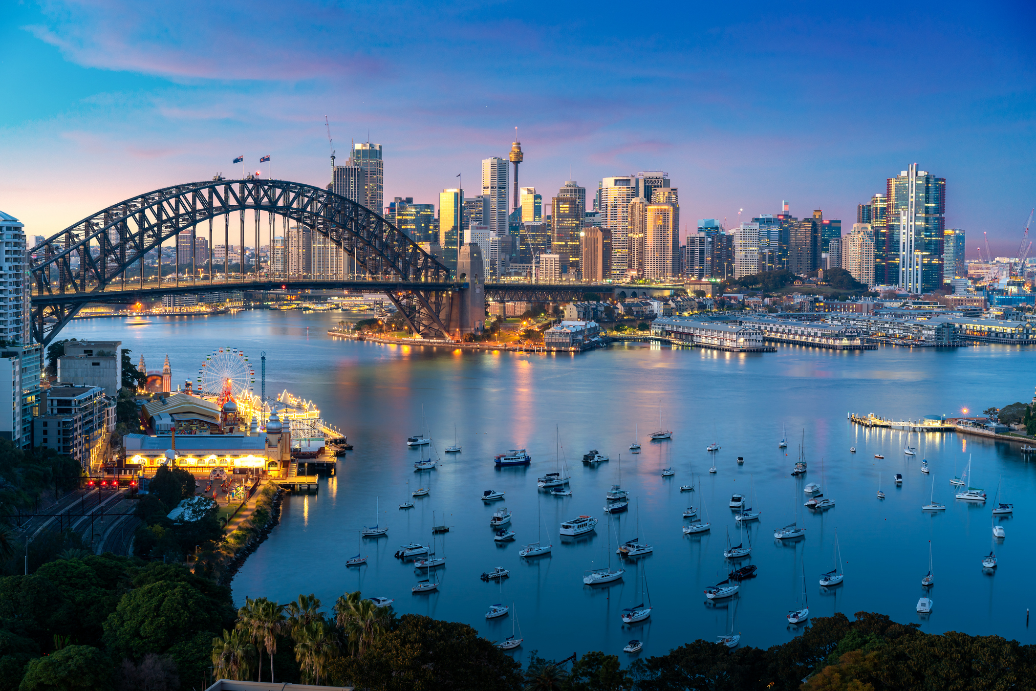 Cityscape image of Sydney, Australia with Harbor Bridge and Sydney skyline during sunset