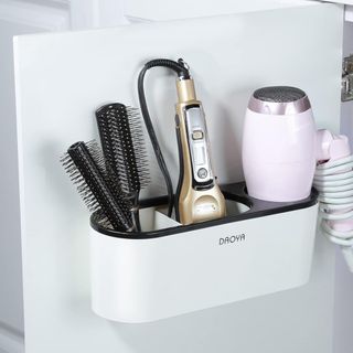 a white bathroom cabinet storage basket with hair tools