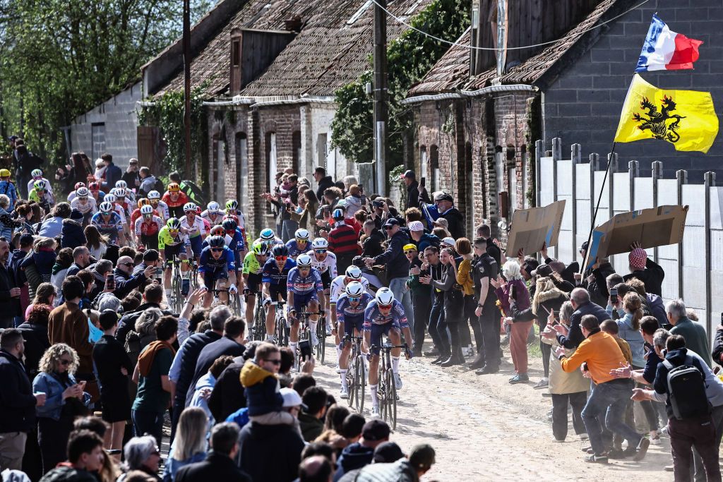 The pack of riders cycles over the first cobblestone sector (dubbed "sector 29") during the 121st edition of the Paris-Roubaix one-day classic cycling race, 260km between Compiegne and Roubaix, northern France, on April 7, 2024. (Photo by Anne-Christine POUJOULAT / AFP)