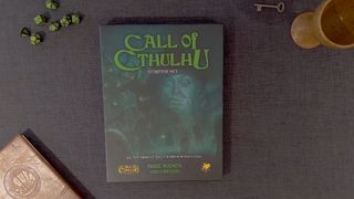 Call of Cthulhu Starter Set box on a gray surface, with dice, a goblet, key, and notebook surrounding it