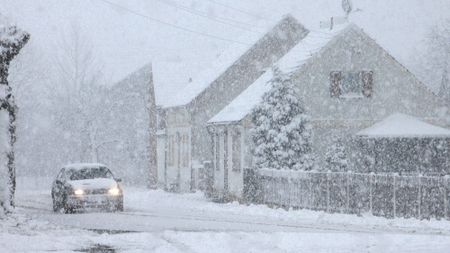 snow storm with car and house in background