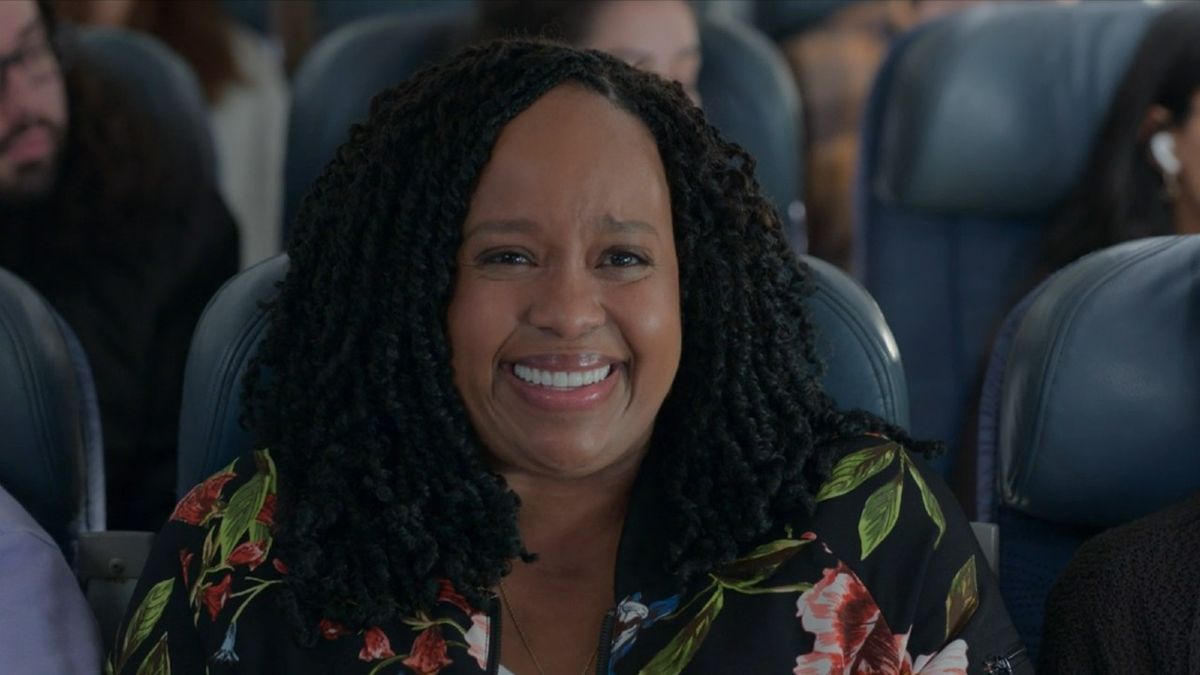 Natasha Rothwell smiling on a plane in How to Die Alone.