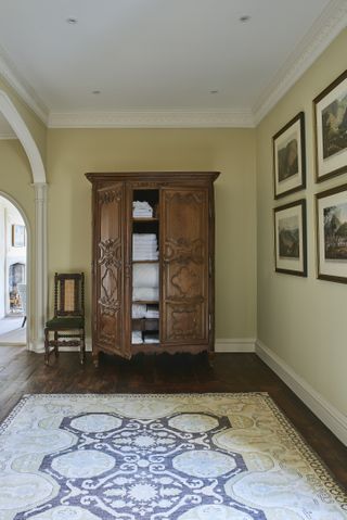 hallway with carved wooden cupboard with linens