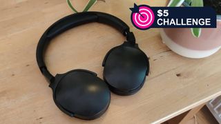 The Generic P2961 headphones in black on a wooden table, with TR's $5 Challenge badge