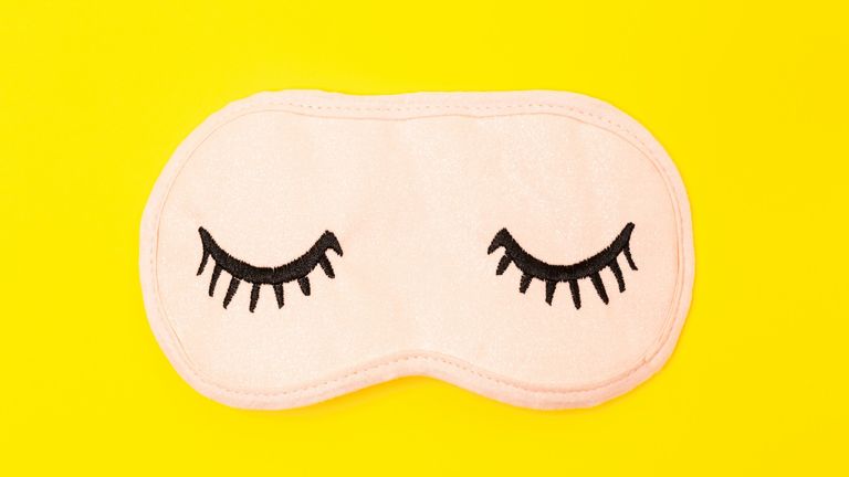 A sleep mask with embroidered eyelashes on the front 