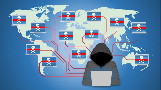 Ilustración de un hacker representado con una capucha trabajando en una laptop, frente a un mapa del mundo. El mapa muestra múltiples conexiones entre computadoras marcadas con íconos de calaveras, simbolizando una red global de dispositivos comprometidos o un ataque de botnets.