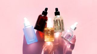 Row of bottles with lotions. Beauty product of the year - serum and gel - stock photo