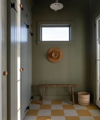 entryway mudroom with yellow checkerboard flooring and small bench seat