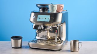 the breville oracle dual boiler / sage oracle dual boiler in stainless steel, showing its touchscreen, steam wand, built in grinder, and espresso shots