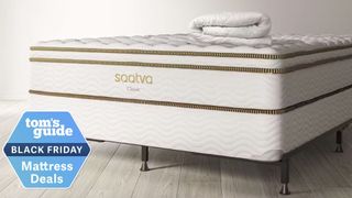 The Saatva Classic mattress on the foundation with a mattress pad folded on top