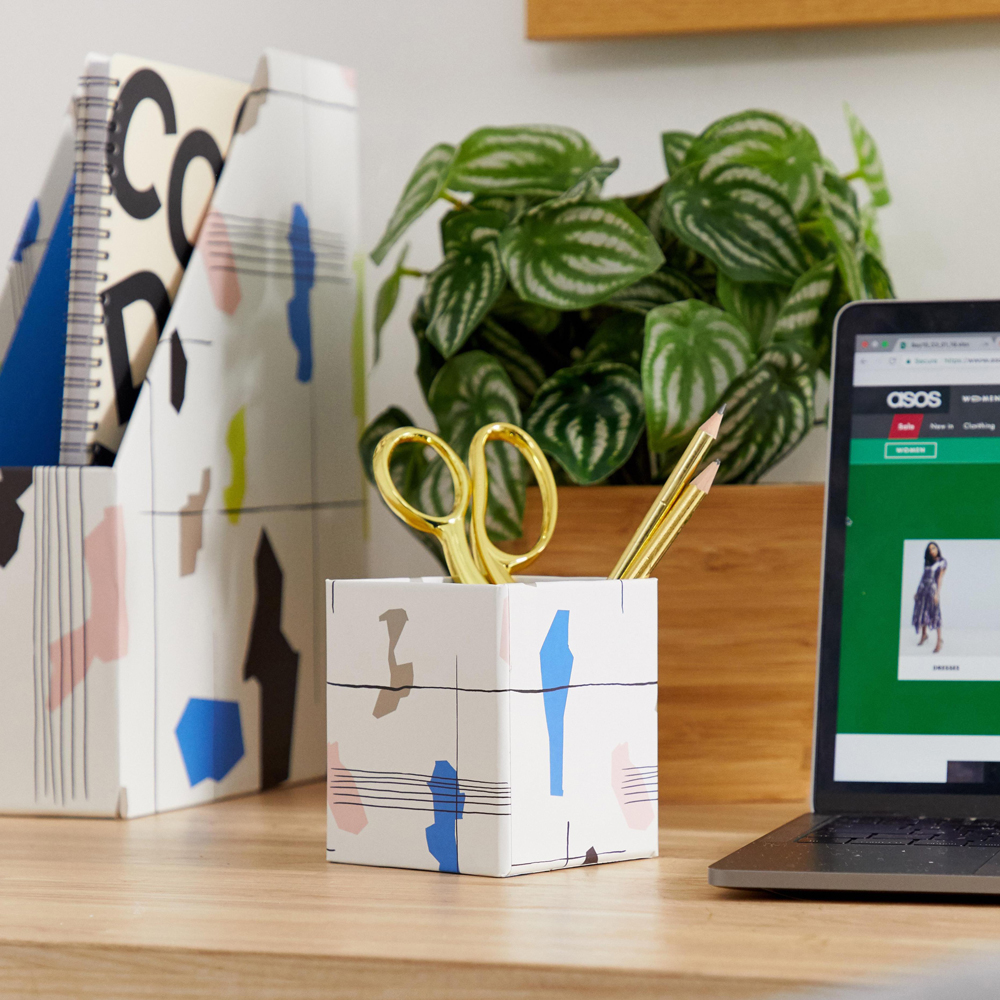 room with wooden desk having laptop scissor and pencil
