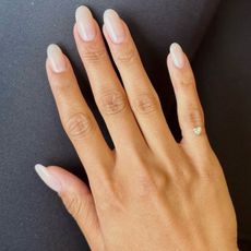 A photo of a sheer white manicure design with oval shapes nails