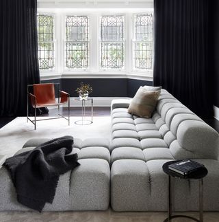 A black living room with a white tufted sectional