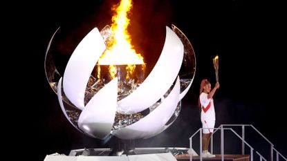 tokyo, japan july 23 naomi osaka of team japan lights the olympic cauldron with the olympic torch during the opening ceremony of the tokyo 2020 olympic games at olympic stadium on july 23, 2021 in tokyo, japan photo by patrick smithgetty images
