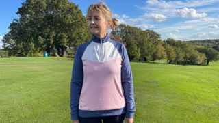 A golfer wears the Crew Clothing Women's Chevron Golf Half Zip Sweatshirt