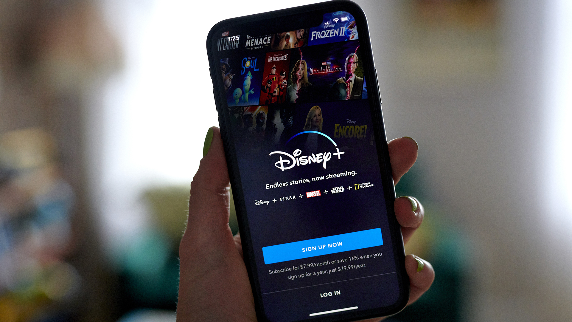 The Disney+ sign-up page on a mobile phone being held in a left hand
