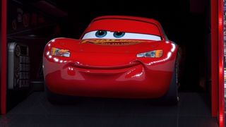 Lightning McQueen steps out from a truck ready to race in Cars