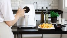 Woman cooking with a white air fryer