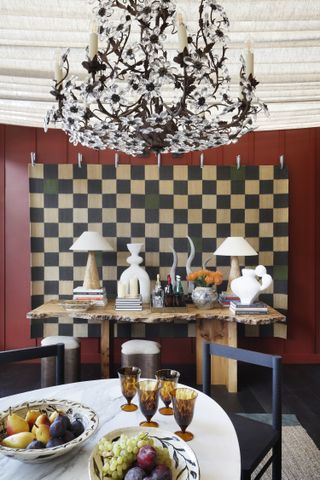 A dining room with modern objects and a traditional chandelier