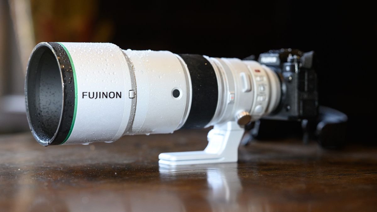 The Fujifilm XF 400mm F4.5 R LM OIS WR telephoto prime lens attached to a Fujifilm X-H2S camera, on a wooden table