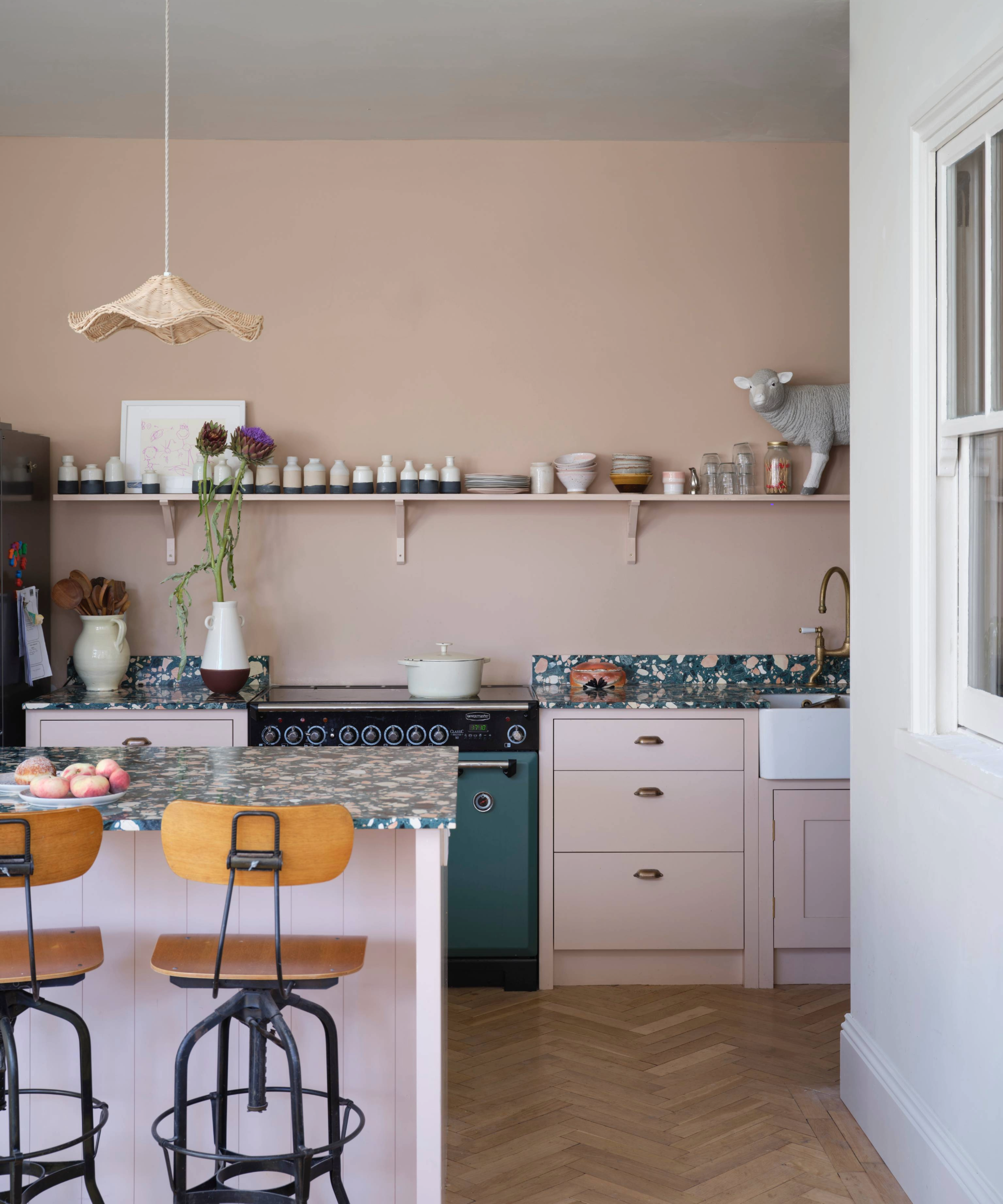 Kitchen with pink walls and cabinets, with a blue and pink worktop