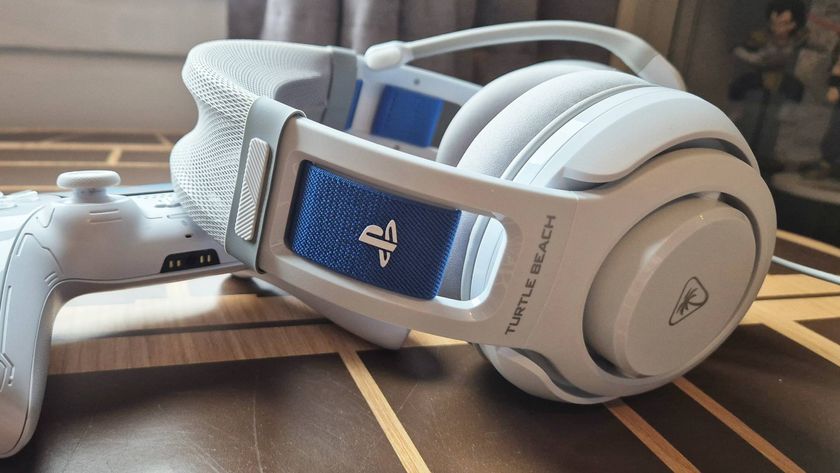 Photo of a white headset sitting on a wooden desk, with a PlayStation logo on its side.