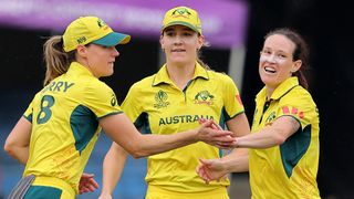 Megan Schutt of Australia celebrates with teammates Ellyse Perry and Annabel Sutherland during their victory against South Africa in the Women's Cricket World Cup