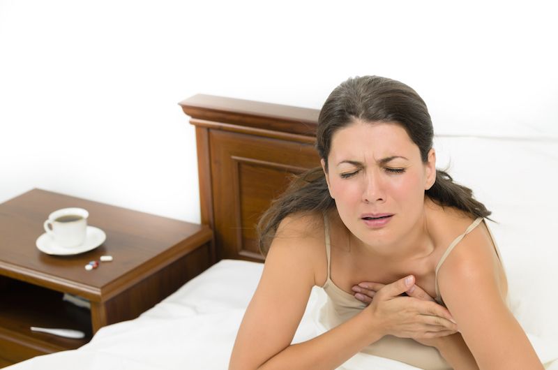 woman having a heart attack in bed