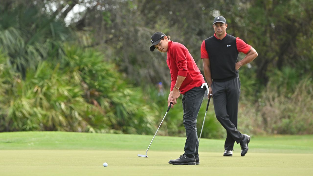 Charlie Woods takes a putt with Tiger Woods looking on behind