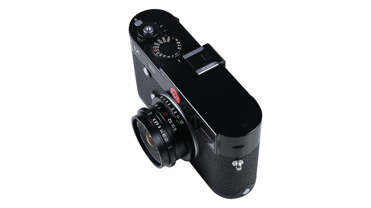 Laowa 15mm f/5 Cookie FF lens, mounted to a camera, against a white background