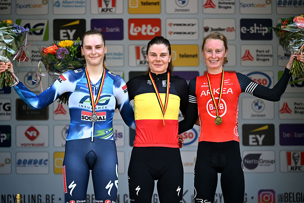 Lotte Kopecky in the Belgian champion&#039;s jersey on the podium with Lotte Claes and Marthe Goossens after winning the 2025 women&#039;s individual time trial title