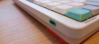 A white NuPhy Air75 V2 keyboard on a wooden desk