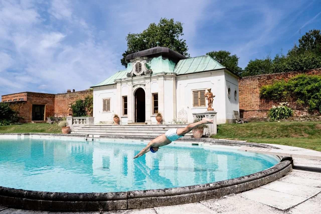 dives into the pool built for Chips Channon at Kelvedon Hall, Essex.