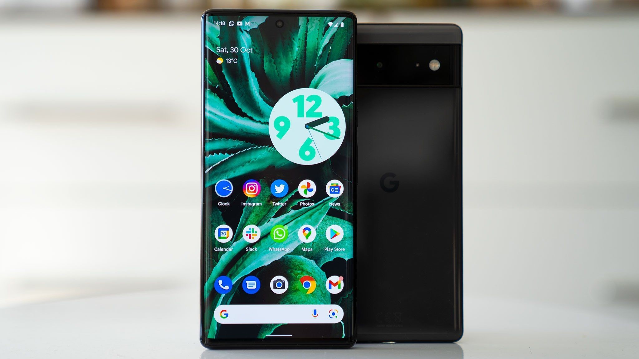 Google Pixel 6 Pro e Google Pixel 6 ficam verticalmente sobre uma mesa branca