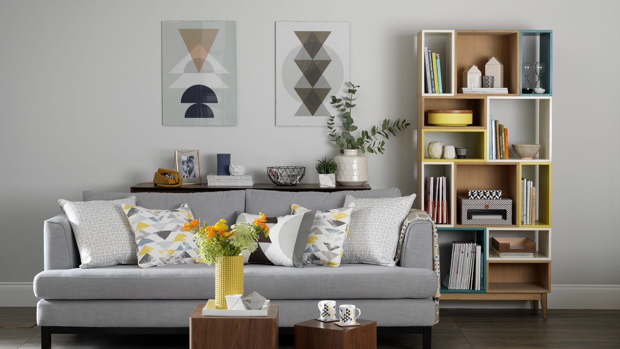 Gey living room with sofa, coffee table, artwork and bookshelves