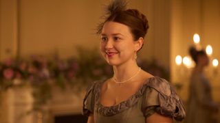 Liv Hill in a beige dress with a feather in her hair as young Mary in Miss Austen.