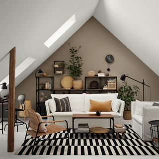 ochre living room with black and white rug, white sofa and armchair, shelving unit, loft style ceiling, office area