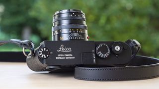 Leica M11-P top view on wooden table with 50mm f/2 lens attached