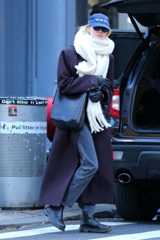 Gigi Hadid walks in Soho wearing a purple overcoat and extra oversize scarf