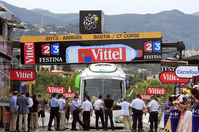 Officials try to figure out what to do to get the Orica-GreenEdge bus unstuck before the sprinters arrive