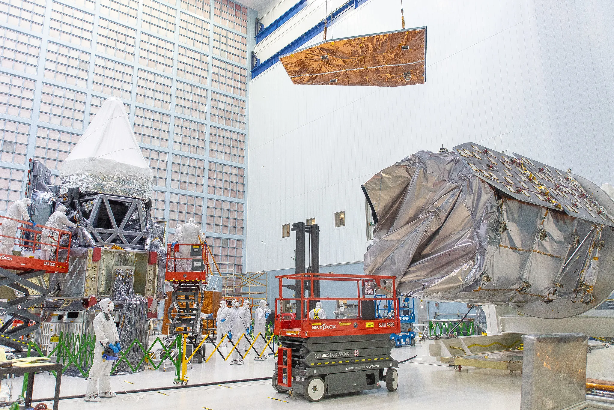 People in a clean room with construction equipment.