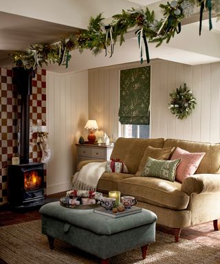 cozy living room with log burner and Christmas garland attached to ceiling beam