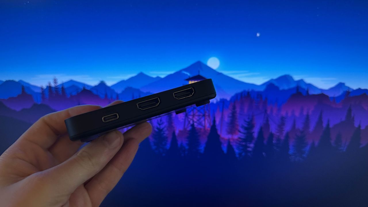 NZXT Signal HD60's connection ports being held in front of the camera by a reviewer