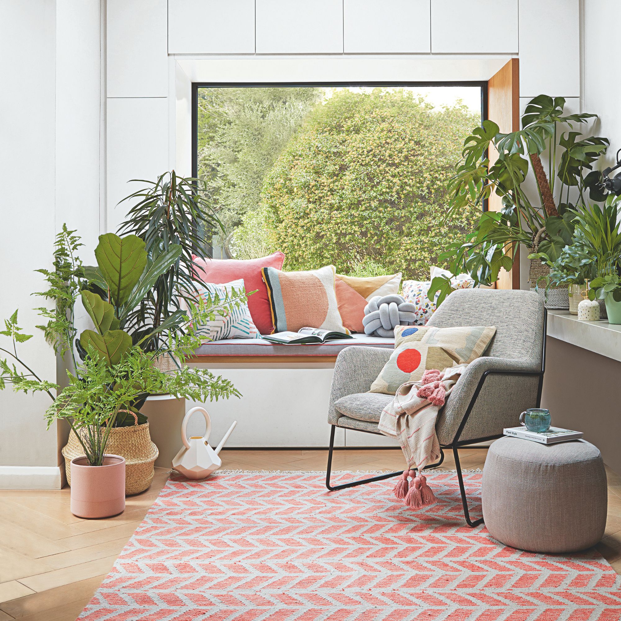 A white and airy living room with house plants and a window seat
