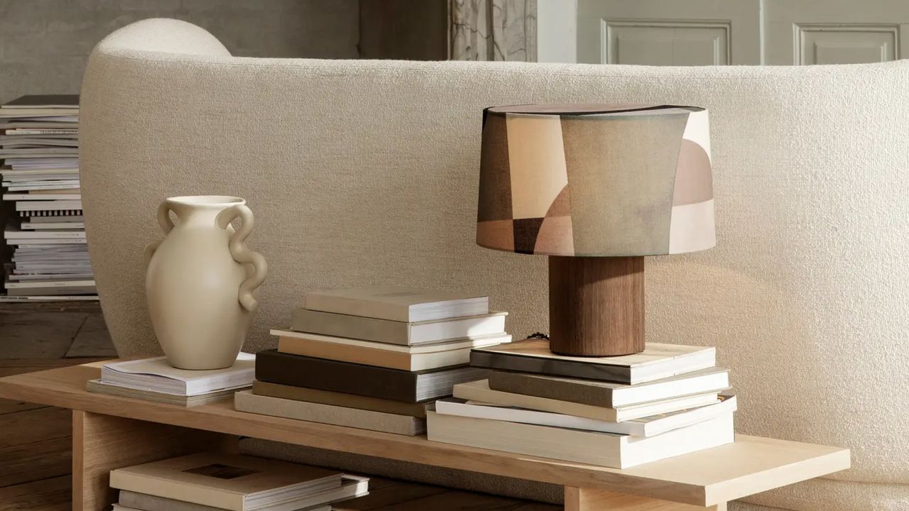 books, lamp, and vase lined up on a shelf