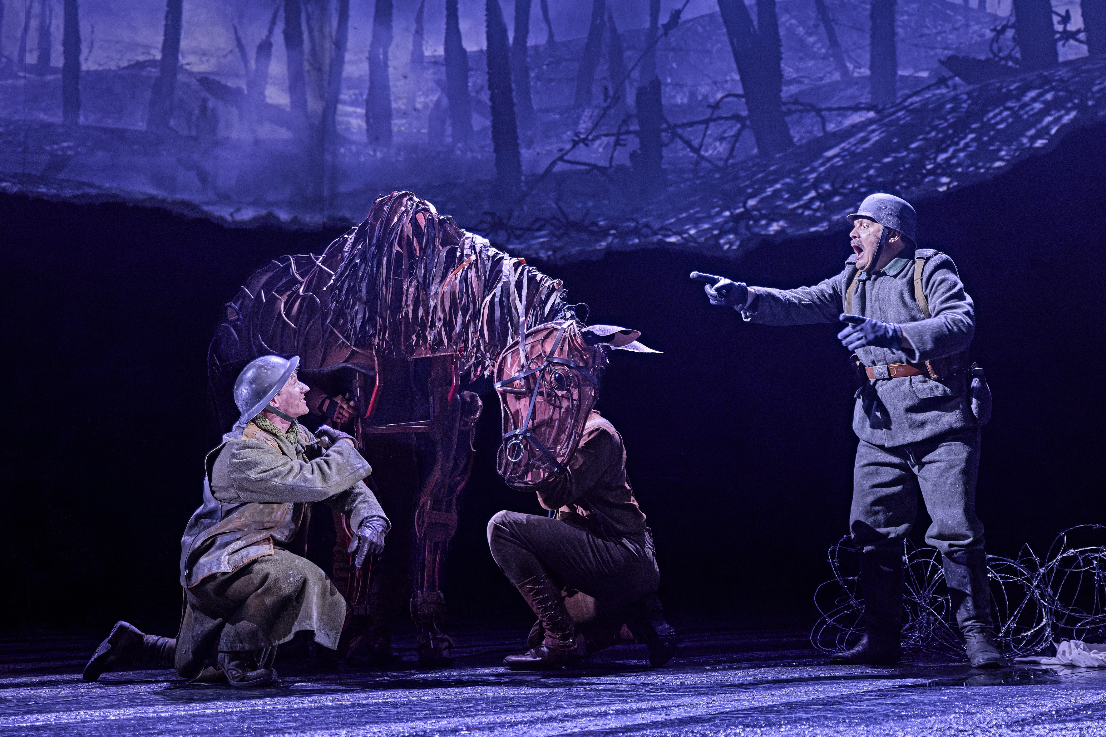 Scene from War Horse 2026 on stage at National Theatre, with life-sized horse puppet and actors as soldiers