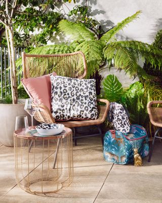 outdoor chair with comfy cushions surrounded by plants