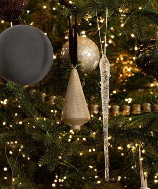 Ornaments on a Christmas tree, strung with warm white lights.